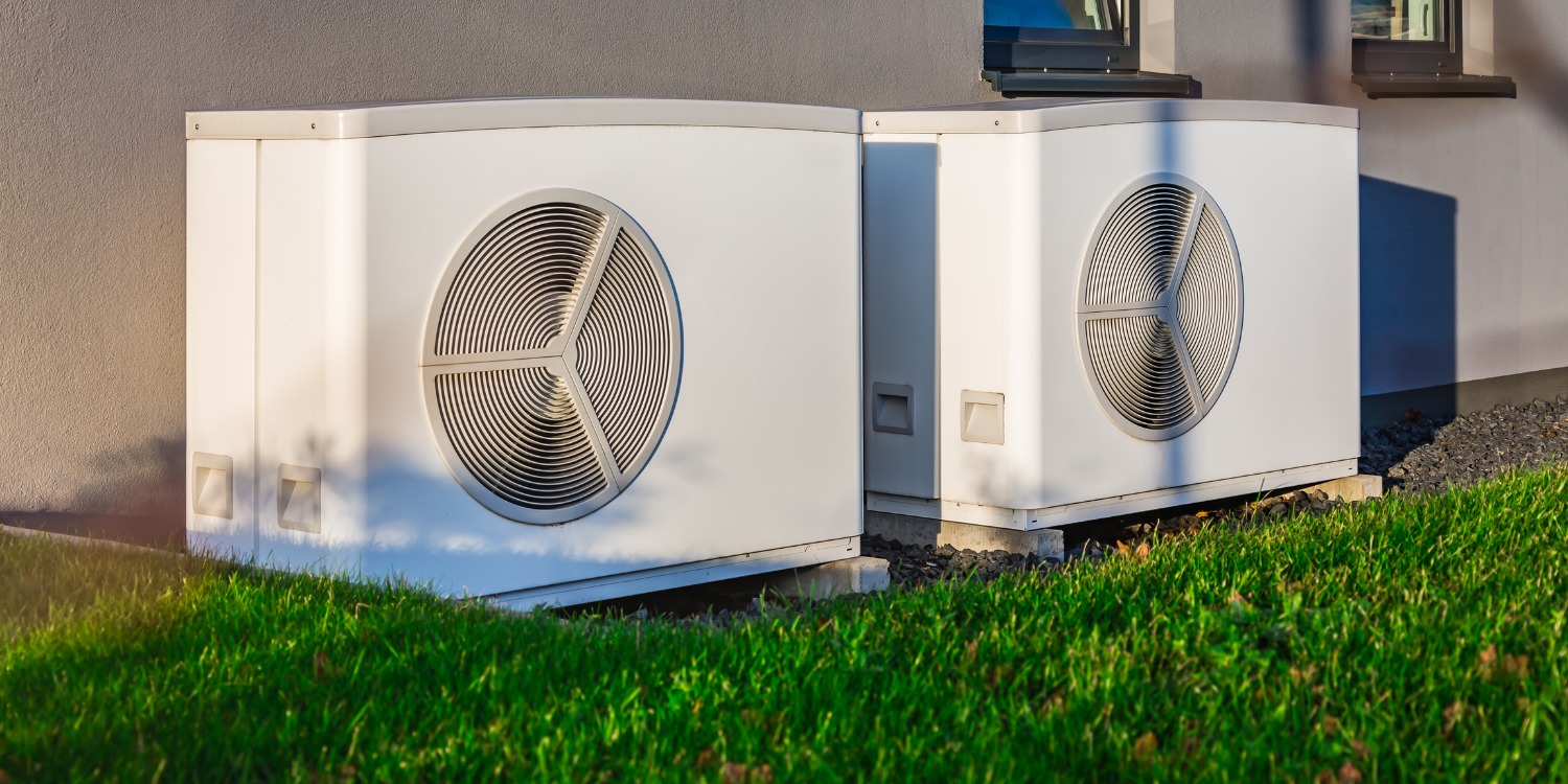 Two white heat pumps outside of home - Switching From Oil to Heat Pumps: Rebates & Benefits in 2024 